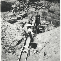 Lavage d'alluvions aurifères dans un sluice, par des chercheurs d'or isoles.