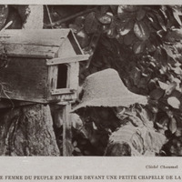 Vieille femme du peuple en prière devant une petite chapelle de la forêt